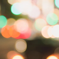 細かく重なり合った玉ボケと暖色の光が密集する背景の写真