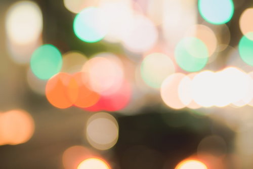 細かく重なり合った玉ボケと暖色の光が密集する背景