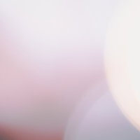 薄紫色にぼけた玉ボケの光、ライトアップされた夜景の写真