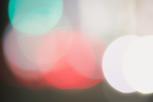 ピンクとグリーンが重なる光のボケ背景、玉ボケのネオン風デザイン