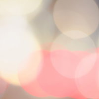 ピンクとオレンジの光が重なる玉ボケの背景の写真