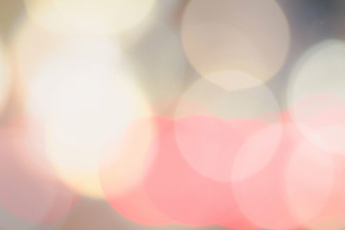 ピンクとオレンジの光が重なる玉ボケの背景