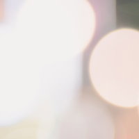 白い光と浮かぶ光球のボケ、暖色系の玉ボケが重なる抽象的な光の表情の写真