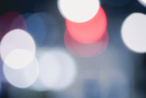 白色の玉ボケと赤い光が重なる抽象背景