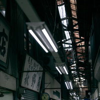 商店街の天井からぶら下がる蛍光灯の照明風景の写真