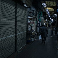 薄暗いアーケード内の六角橋仲見世通りのシャッター街の写真