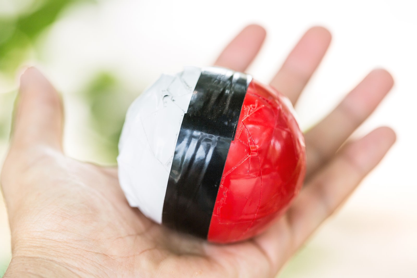 手で握られた紅白ボールとスマートフォン