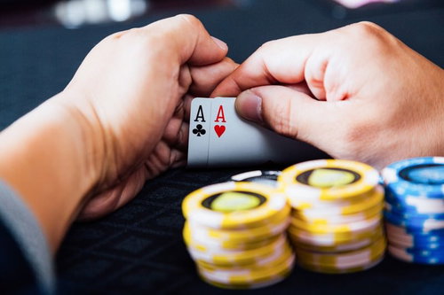 両手で絞るトランプとチップ|カジノゲームのプレイシーン