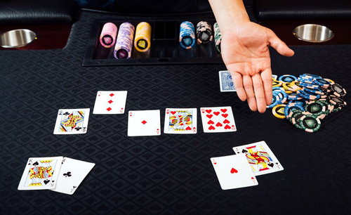 ポーカーで勝利を収めるディーラーの手とチップ