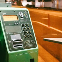 使わなくなった緑色の公衆電話機 駅前の懐かしいテレホンカード対応電話の写真