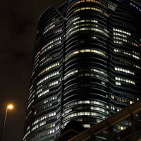 夜の首都高越しに見上げる六本木ヒルズの写真
