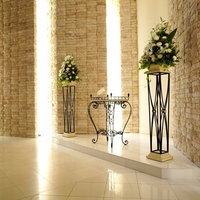 花が飾られた装飾台が並ぶ清潔感ある空間の写真