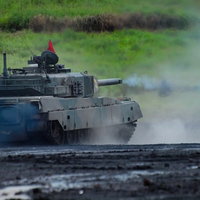 砲煙を上げて走行する総火演の90式戦車の写真