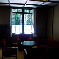 赤いクッションが並ぶレトロな応接室の写真