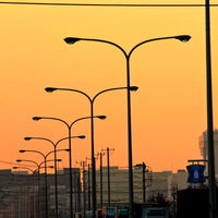 夕焼けの空と産業道路に連なる街灯の写真