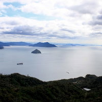 高台から見下ろす瀬戸内海の島々と船の写真