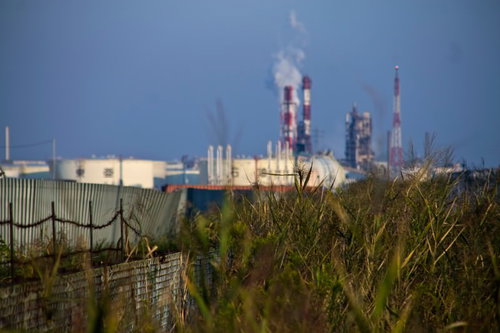 フェンス越しに見える遠くの工業地帯