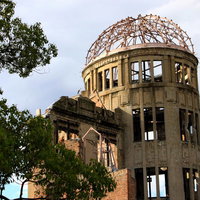 夕日を背に受ける原爆ドームの骨組みの写真