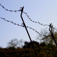 青空を背景にした侵入禁止の有刺鉄線の写真