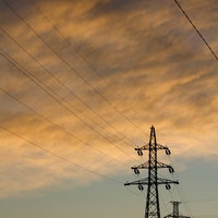 夕焼け空にそびえる鉄塔と電線の写真