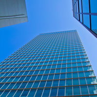 青空を背景にした金色の枠のガラス張りビルの写真