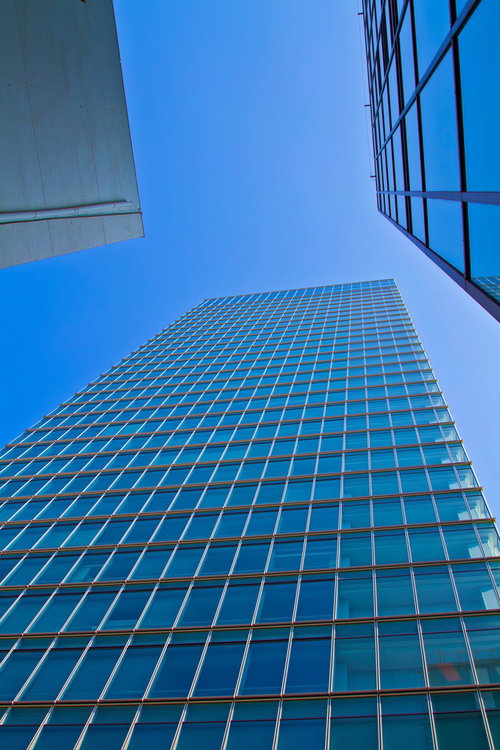 青空を背景にした金色の枠のガラス張りビル