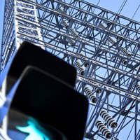 青空を背景にした歩行者信号と送電鉄塔の写真