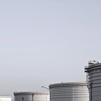 曇り空の下に並ぶ工業用の重油タンクの写真