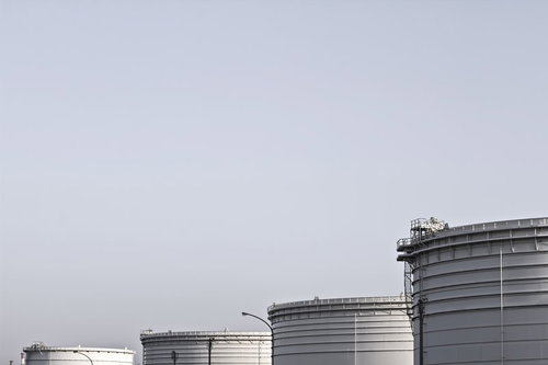 曇り空の下に並ぶ工業用の重油タンク