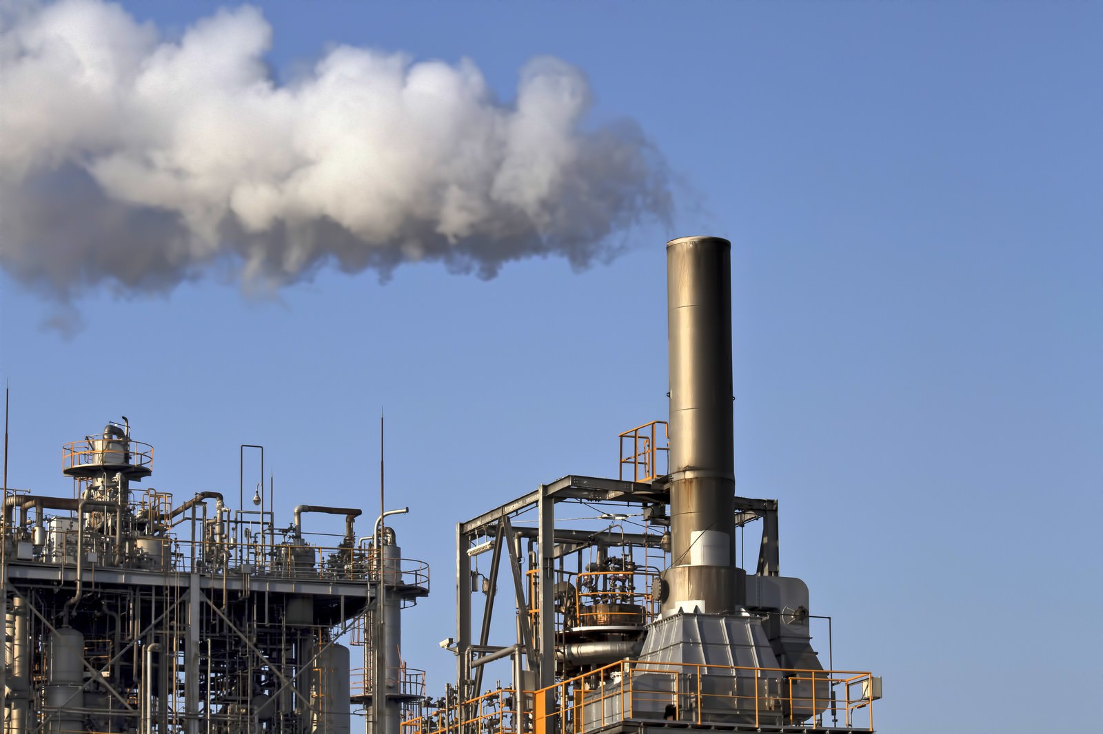青空に煙を吐く工場の煙突