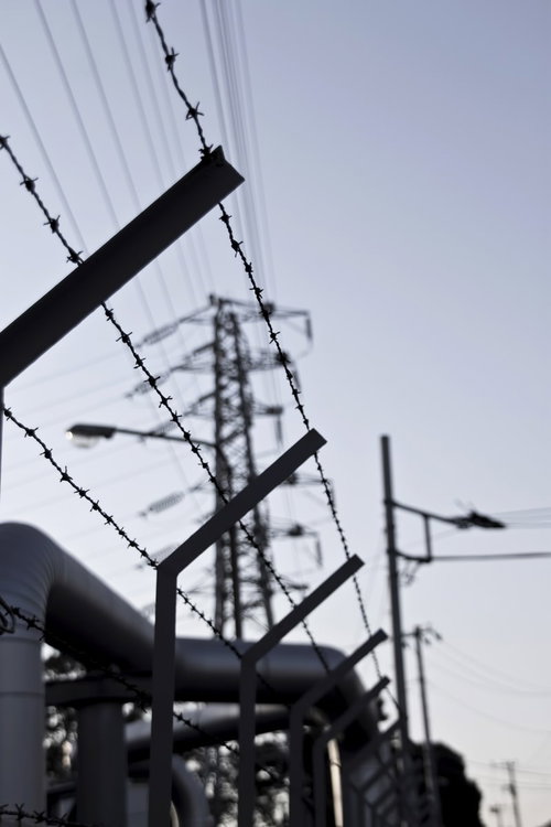 鉄塔を背景にした工業地帯の有刺鉄線