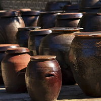 模様が施された陶器の壺が並ぶ屋外展示の写真