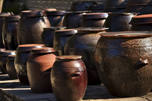 模様が施された陶器の壺が並ぶ屋外展示