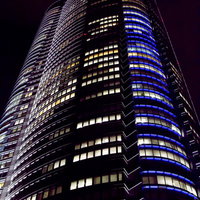 夜空に浮かぶライトアップされた六本木ヒルズの写真