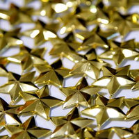 光を反射する金色の星の飾りが並ぶの写真