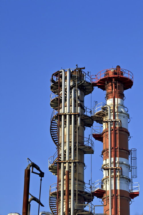 青空にそびえる工場の2本の煙突と階段