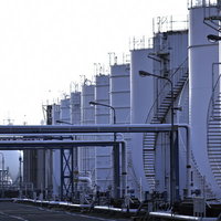 パイプラインが続く工場に建ち並ぶタンク群の写真