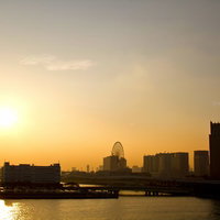 観覧車とビル群が並ぶ夕焼けのお台場の写真
