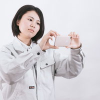 原状回復確認用にスマホで撮影する作業着姿の現場責任者の写真