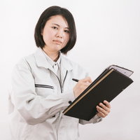 雨風の中で傘を持つ女性現場監督の写真