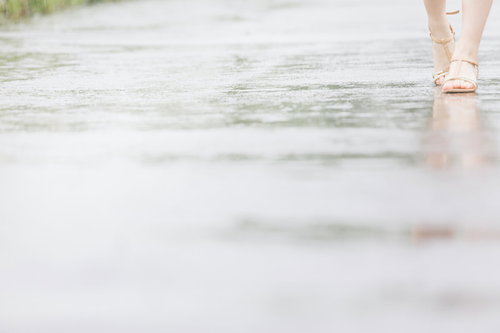 梅雨の日の足元とサンダルと水たまり
