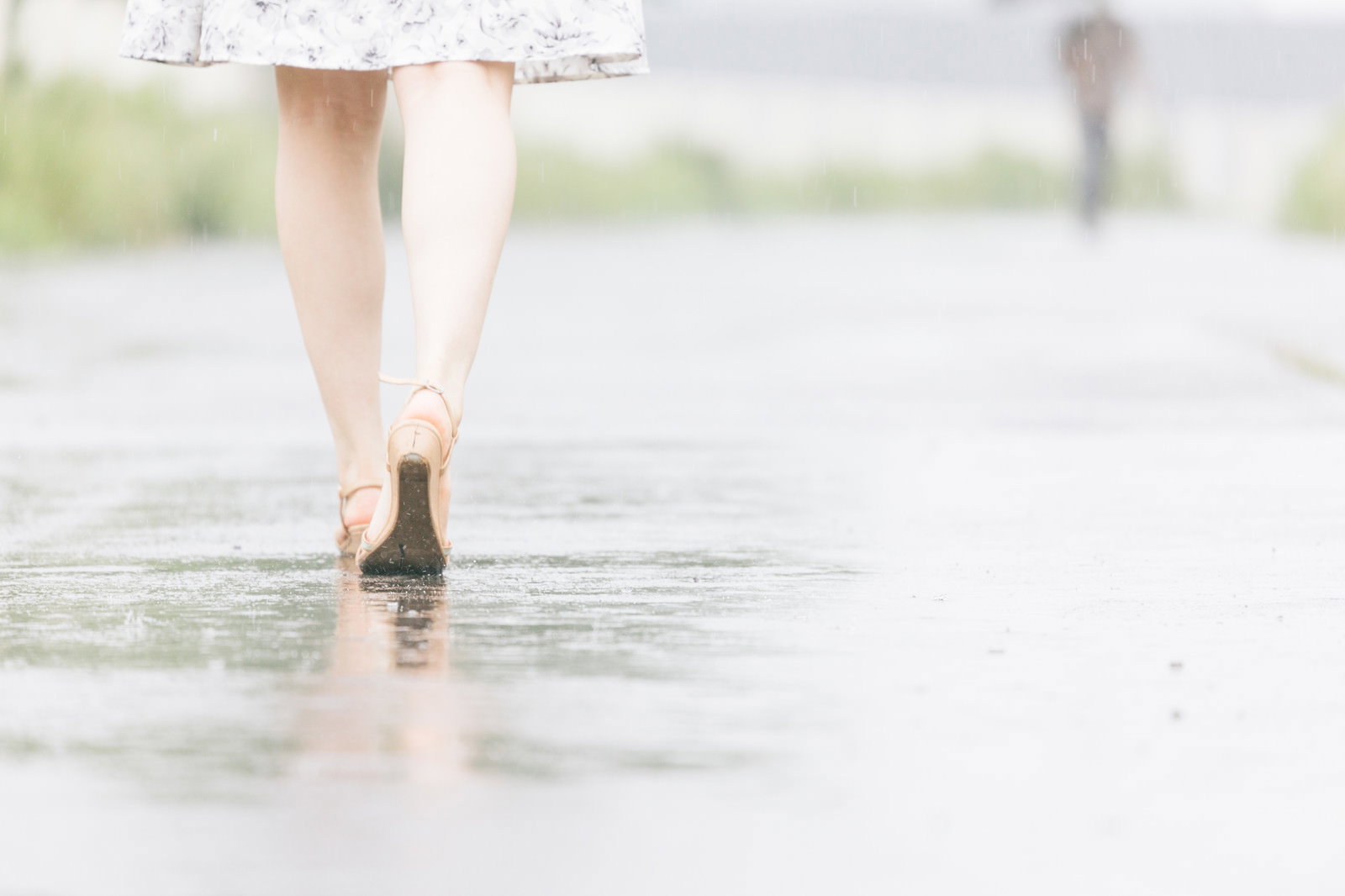 雨上がりの濡れた道路を歩く人の足元、水たまりに反射する様子［モデル：佐竹PP］