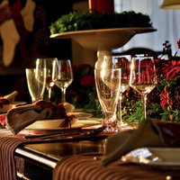 赤い薔薇とワイングラスが並ぶテーブルセッティングの写真