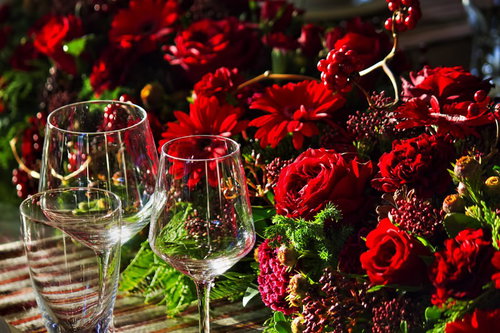 赤い薔薇の花束とワイングラスが並ぶテーブル