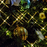 キラキラした粒が入ったクリスマスツリーの金色ボール飾りの写真