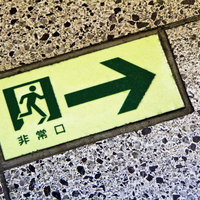 床に埋め込まれた非常口のタイル標識の写真