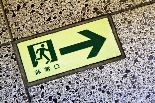 床に埋め込まれた非常口のタイル標識