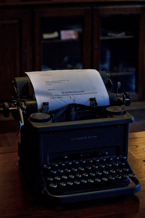 紙が差し込まれた古いタイプライターの正面