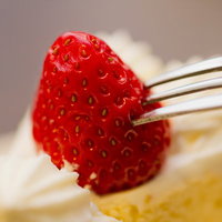 フォークに刺さった赤いいちごのクローズアップの写真