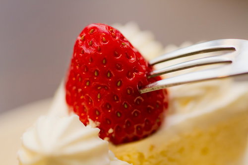 フォークに刺さった赤いいちごのクローズアップ
